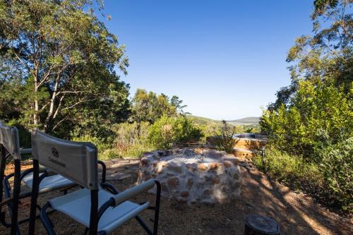 a chair and a fire pit in a yard at Kyles Forest Cabin in Kafferkop