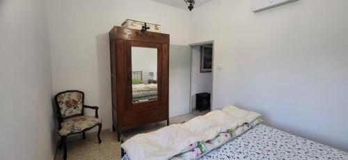 a bedroom with a mirror and a bed and a chair at Casa al Vantaggio in Orvieto