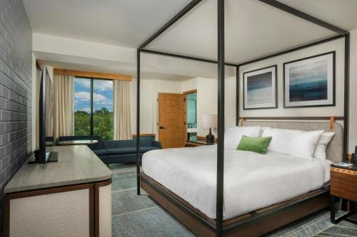 a bedroom with a bed and a living room at Merriweather Lakehouse Hotel, Autograph Collection in Columbia