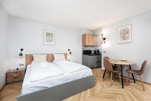 a bedroom with a bed and a table and a kitchen at Nowy Hotel Monika - by Upstairs in Kraków