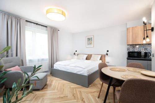 a bedroom with a bed and a table and chairs at Nowy Hotel Monika - by Upstairs in Kraków
