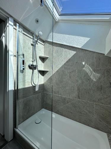 a shower with a glass door in a bathroom at Mertinkus Nordseehotel in Cuxhaven