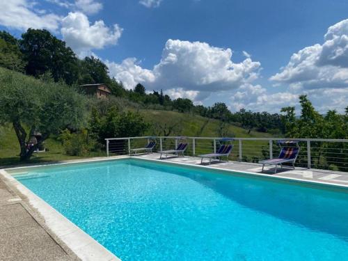 a swimming pool with two chairs and a fence at Ala di Maniero in Agriturismo Valdrago in Toscana, nel Verde Mugello sulle Colline di Firenze Autodromo Mugello Circuit in Borgo San Lorenzo