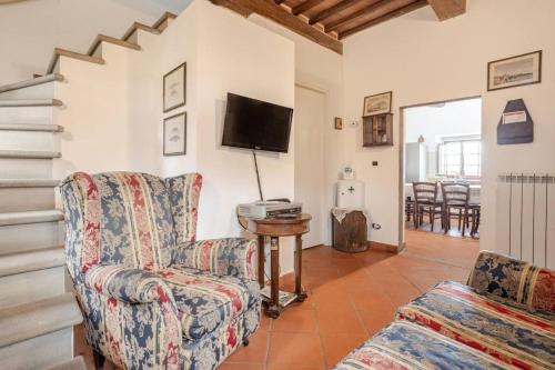a living room with a chair and a tv at Ala di Maniero in Agriturismo Valdrago in Toscana, nel Verde Mugello sulle Colline di Firenze Autodromo Mugello Circuit in Borgo San Lorenzo