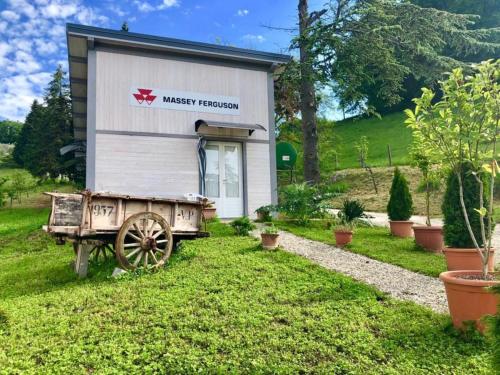 a tiny house with a wagon in the yard at Ala di Maniero in Agriturismo Valdrago in Toscana, nel Verde Mugello sulle Colline di Firenze Autodromo Mugello Circuit in Borgo San Lorenzo