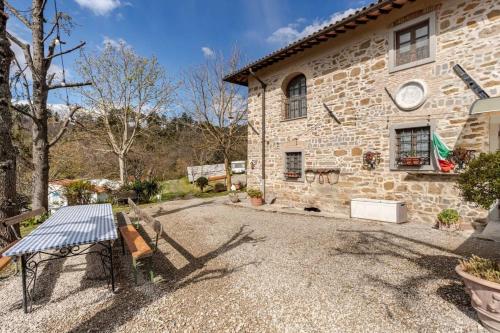 a stone house with a table in front of it at Ala di Maniero in Agriturismo Valdrago in Toscana, nel Verde Mugello sulle Colline di Firenze Autodromo Mugello Circuit in Borgo San Lorenzo