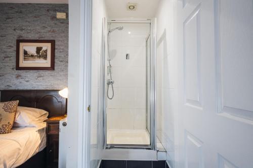 a bathroom with a shower with a glass door at White Lion Royal Hotel in Bala