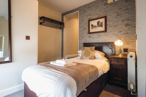 a bedroom with a bed and a mirror at White Lion Royal Hotel in Bala