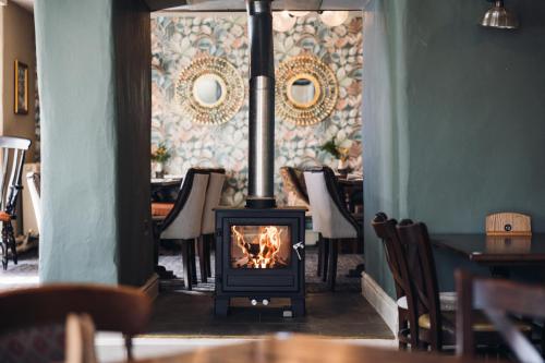 a fireplace in a dining room with chairs and a table at White Lion Royal Hotel in Bala