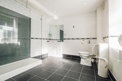 a bathroom with a toilet and a glass shower at White Lion Royal Hotel in Bala