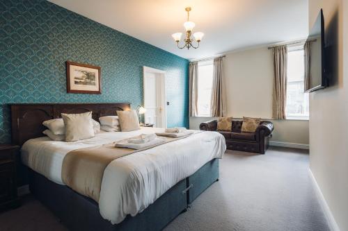 a bedroom with a large bed and a couch at White Lion Royal Hotel in Bala
