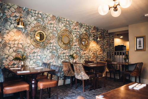 a restaurant with tables and mirrors on the wall at White Lion Royal Hotel in Bala