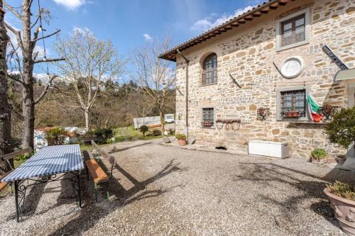 a stone house with a table in front of it at Ala di Maniero in Agriturismo Valdrago in Toscana, nel Verde Mugello sulle Colline di Firenze Autodromo Mugello Circuit in Borgo San Lorenzo