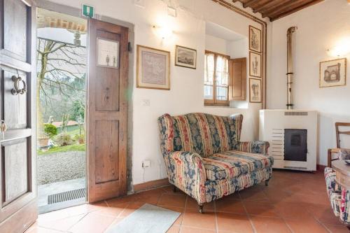 a living room with a chair and a fireplace at Ala di Maniero in Agriturismo Valdrago in Toscana, nel Verde Mugello sulle Colline di Firenze Autodromo Mugello Circuit in Borgo San Lorenzo