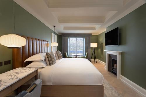 a bedroom with a large bed and a fireplace at JA Mar Hall Scotland in Bishopton
