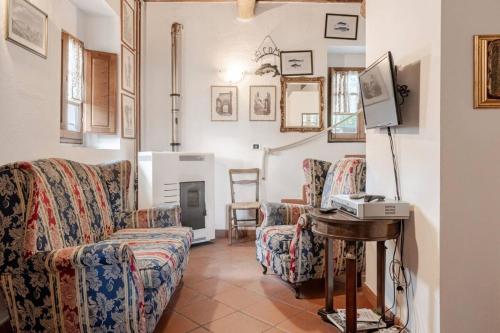 a living room with a couch and a table and a television at Ala di Maniero in Agriturismo Valdrago in Toscana, nel Verde Mugello sulle Colline di Firenze Autodromo Mugello Circuit in Borgo San Lorenzo