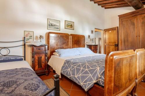 a bedroom with a bed and a wooden headboard at Ala di Maniero in Agriturismo Valdrago in Toscana, nel Verde Mugello sulle Colline di Firenze Autodromo Mugello Circuit in Borgo San Lorenzo