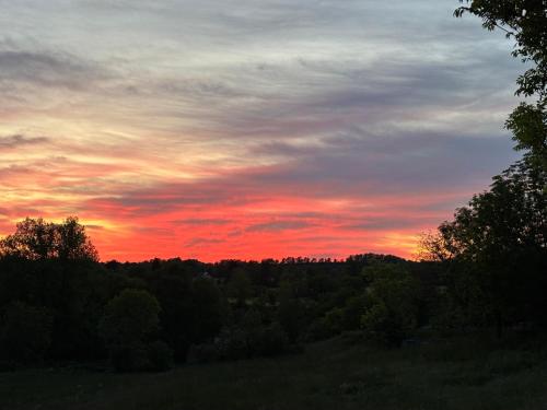 a sunset in the sky over a forest of trees at Gite Entre Causse et Vallon, tout confort pour 4 personnes dans grange rénovée au coeur de l'Aveyron in Salles-la-Source