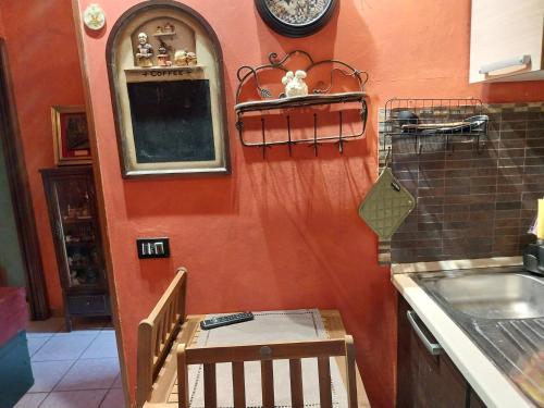 a kitchen with an orange wall and a sink at Casita Esperanza in Copparo