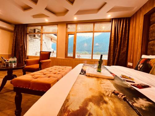 a hotel room with a bed and a bottle of wine at Hill River Resort - Central Heated & Air Cooled - Near Mall Road , Best Property of Manali 2024- 2025 in Manāli