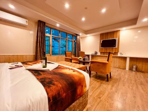 a hotel room with a large bed and a desk at Hill River Resort - Central Heated & Air Cooled - Near Mall Road , Best Property of Manali 2024- 2025 in Manāli