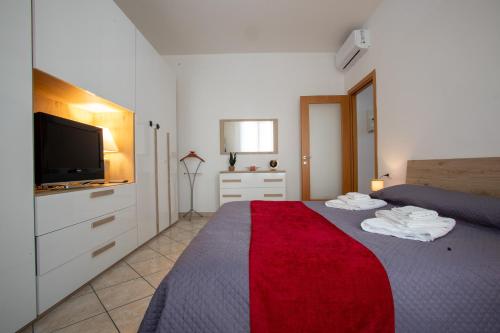 una camera da letto con un letto e una TV a schermo piatto di Ilaria House - 10 Min dal centro di Como a Como