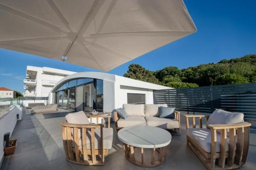 a patio with a table and chairs and an umbrella at The Gem Loft City Apartment in Rhodes Town