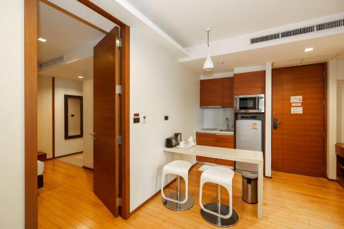 a kitchen with a counter and stools in a room at Marvin Suites Hotel in Bangkok