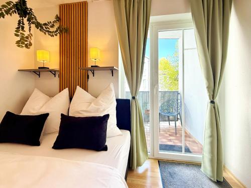 a bedroom with a bed and a sliding glass door at !GoldPath! Passau - Central - Innpromenade - Uniwiese in Passau