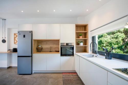 a kitchen with white cabinets and a large window at The Gem Loft City Apartment in Rhodes Town