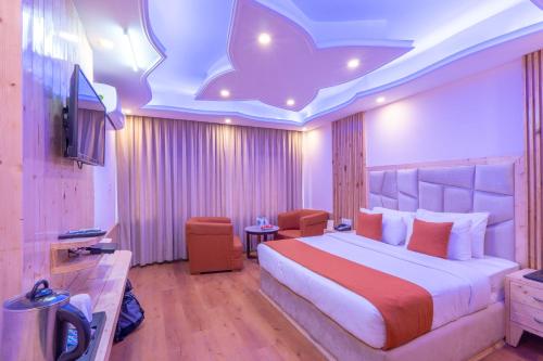 a hotel room with a bed and a television at Hill River Resort - Central Heated & Air Cooled - Near Mall Road , Best Property of Manali 2024- 2025 in Manāli