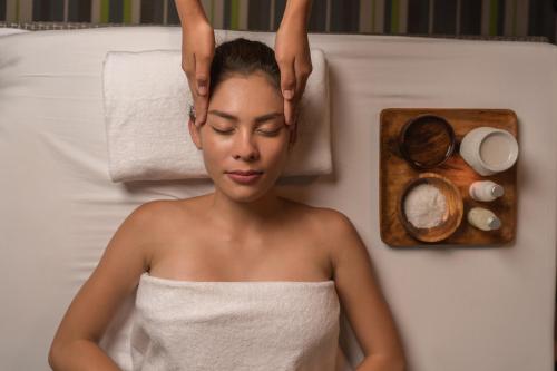 a woman in a bath tub with her hands on her head at Astoria Current in Boracay