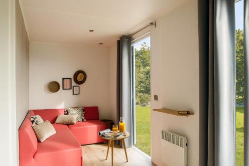 a living room with a red couch and a table at PetraLegna in Porto-Vecchio