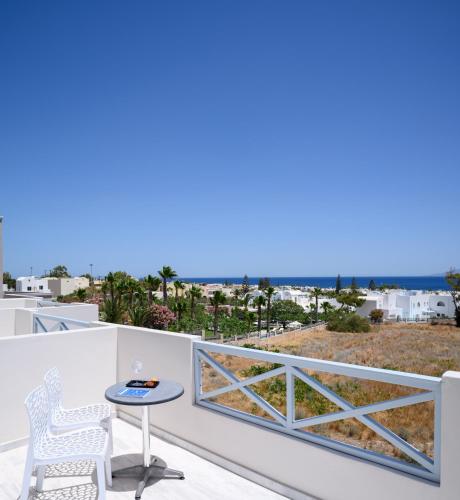 a balcony with a table and chairs and the ocean at Selini Ηotel in Kamari