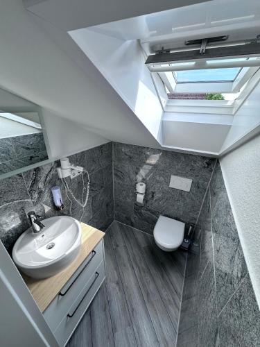 a bathroom with a sink and a toilet at Mertinkus Nordseehotel in Cuxhaven