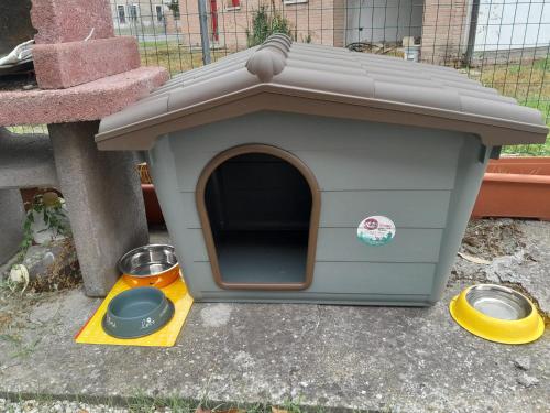 a dog house with two bowls on the ground at Casita Esperanza in Copparo