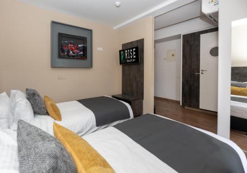 a hotel room with two beds and a tv at Rise Urban Art Hotel in Larnaka