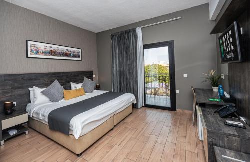 a bedroom with a large bed and a balcony at Rise Urban Art Hotel in Larnaka