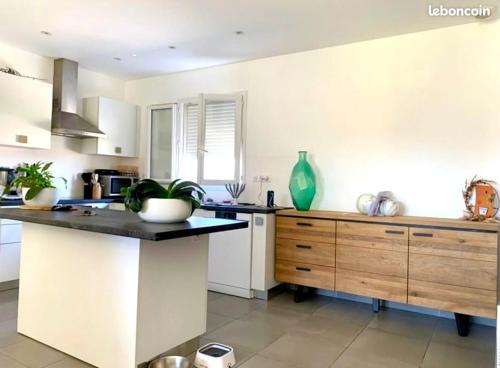 - une cuisine avec des murs blancs et un grand comptoir dans l'établissement Charmante Maison Mitoyenne, à Cervione