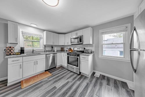 a kitchen with white cabinets and a stove top oven at Pet-Friendly 4BR Near Kennywood & Pittsburgh home in West Mifflin