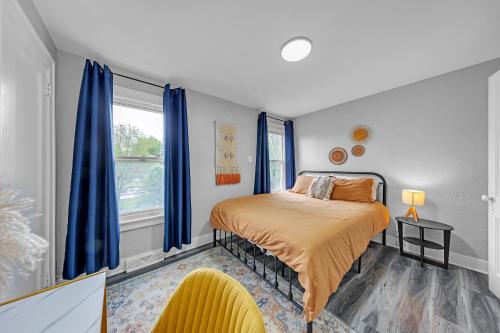 a bedroom with a bed with blue curtains and a window at Pet-Friendly 4BR Near Kennywood & Pittsburgh home in West Mifflin