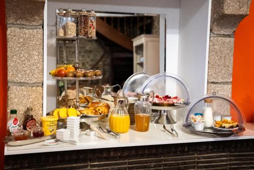 un buffet di cibo su un bancone con frutta e succhi di La Meffrais 1741 - Manoir Élégant - B&B - Parking - 3 min de Dinan a Dinan