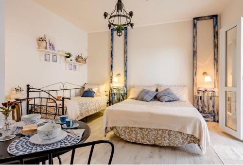 a bedroom with two beds and a table and chairs at Casa Daflanna in Salento - Libeccio (monolocale) in Punta Prosciutto