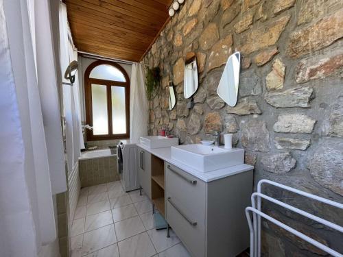 une salle de bains en pierre avec deux lavabos et un mur en pierre dans l'établissement Maison T4 avec Piscine Privée – Bormes-les-Mimosas - FR-1-308-209, à Bormes-les-Mimosas