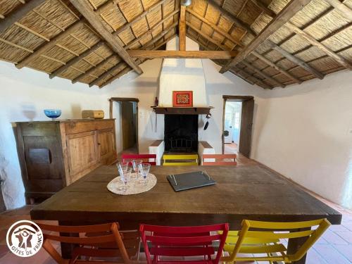 une salle à manger avec une table et des chaises et une cheminée dans l'établissement Séjour Authentique dans Bourrine Traditionnelle à Beauvoir-sur-Mer - FR-1-426-582, à Beauvoir-sur-Mer