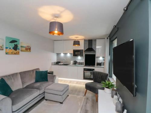 a living room with a couch and a kitchen at Rosie's Retreat, The Bay, Filey in Filey