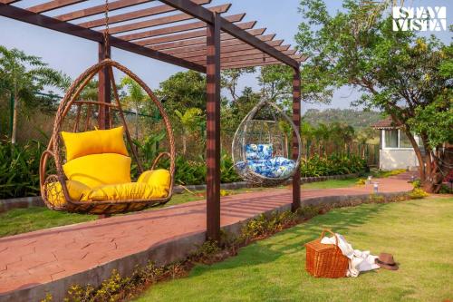 a gazebo with two swings in a yard at StayVista's The Tavern At Canary Farms - Mountain-View Luxury Mansion with Infinity Pool & Games Zone in Lonavala