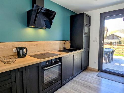 une cuisine avec un évier et une cuisinière four supérieur dans l'établissement Gîte rénové avec jardin à Vignot - FR-1-585-175, à Vignot