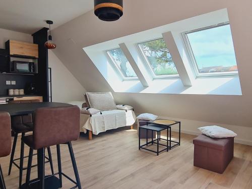 - un salon avec une table et quelques fenêtres dans l'établissement Studio Neuf 23m² Proche Plage et Centre Tout Inclus - FR-1-364-183, à Saint-Brévin-les-Pins