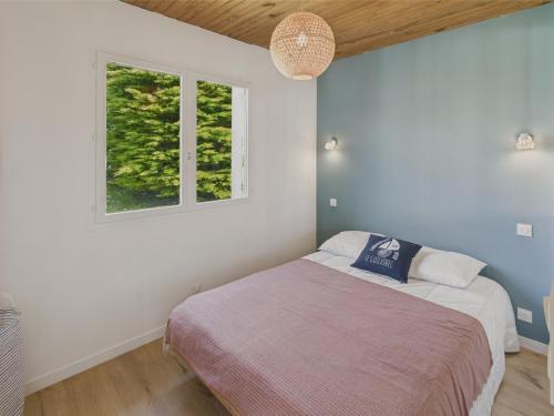 a bedroom with a bed and a window at Maison pour 6 avec jardin à 1 km de la plage in Penmarcʼh